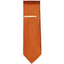 Load image into Gallery viewer, A gold tie bar on a burnt orange necktie