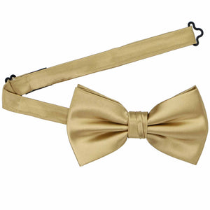 A golden champagne pre-tied bow tie with the collar open