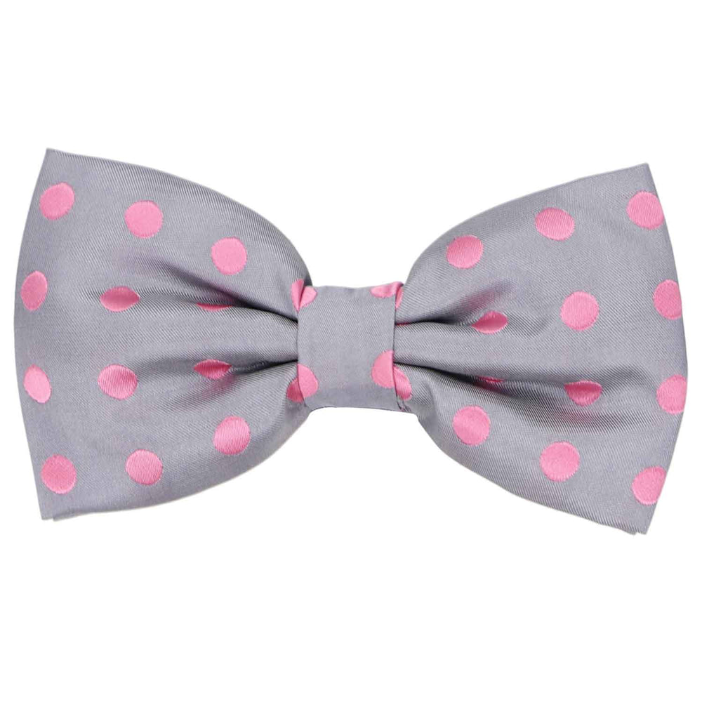 A gray pre-tied bow tie with a repeated pattern of pink polka dots
