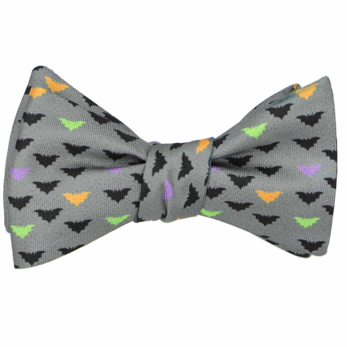 A tied gray self-tie bow tie with a Halloween bat pattern