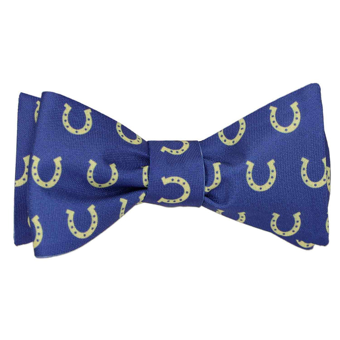 A blue and light yellow horseshoe themed self-tie bow tie, tied