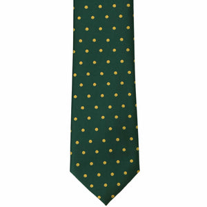 The front of a hunter green and gold polka dot tie, laid out flat