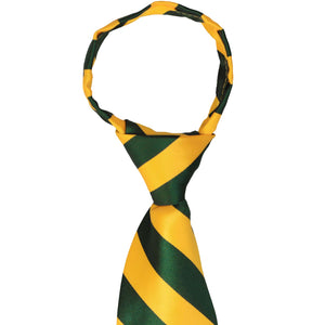 The knot on a hunter green and golden yellow striped zipper tie