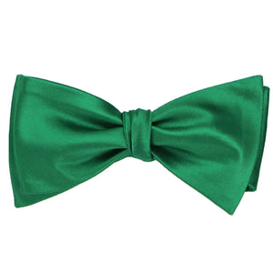A solid kelly green self-tie bow tie, tied