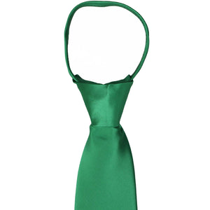 A closeup of the knot on a kelly green zipper tie
