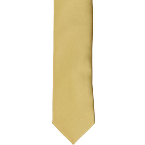 The front of a light gold skinny tie, laid flat