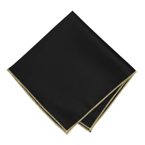 A black pocket square with light gold stitching on the edges, folded into a diamond