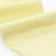 Load image into Gallery viewer, A close-up of pale yellow ribbed knit sock fabric, shown with soft folds against a white background.