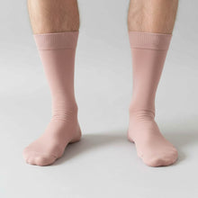 Load image into Gallery viewer, Blush pink socks worn by a man on a light gray background