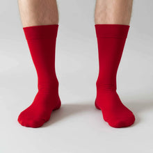 Load image into Gallery viewer, Man wearing red socks on a plain gray background
