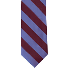 Load image into Gallery viewer, The front of a maroon and deep periwinkle striped tie, laid out flat