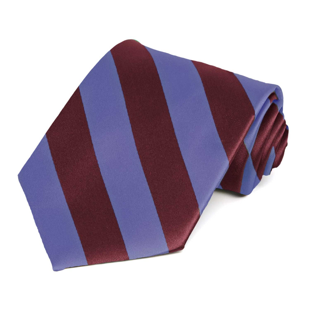 A maroon and deep periwinkle striped tie, rolled to show the tie up close