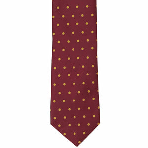The front of a maroon and gold polka dot necktie