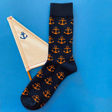 Load image into Gallery viewer, A navy blue and orange boat anchor sock with a sail boat prop on a blue background