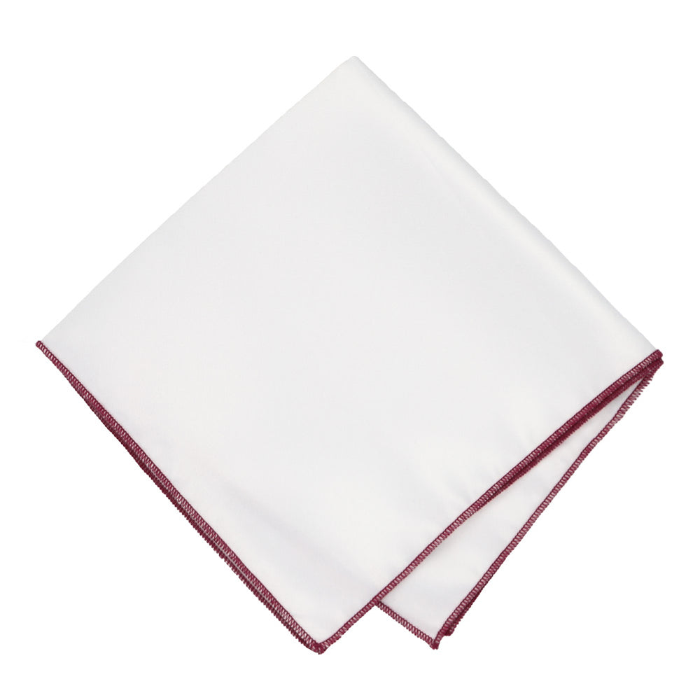 A white pocket square with merlot tipping, folded into a diamond