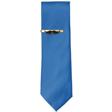 Load image into Gallery viewer, A gold and black mustache tie bar on a blue necktie