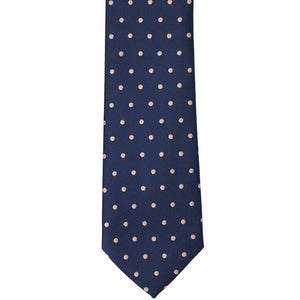 The front of a navy blue and blush pink polka dot necktie