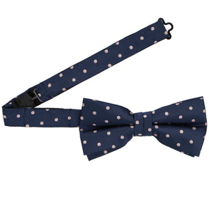 A pre-tied navy blue and blush pink bow tie with the band collar open
