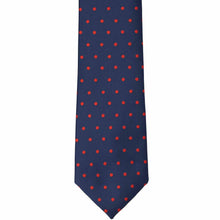 Load image into Gallery viewer, The front of a navy blue and red polka dot tie, laid out flat