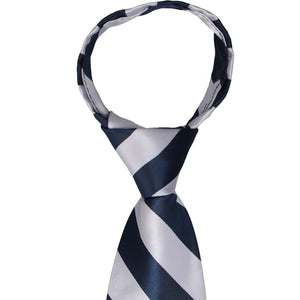 A closeup of the knot on a navy blue and silver striped zipper tie