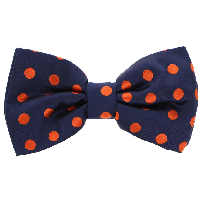 A navy blue bow tie with burnt orange, medium-sized polka dots