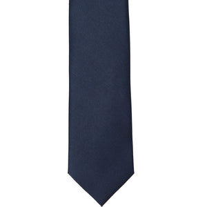 The front of a solid navy blue slim silk tie, laid out flat