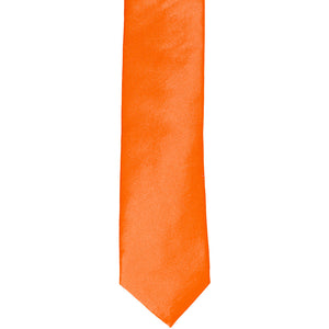 The front of a neon orange skinny tie, laid flat