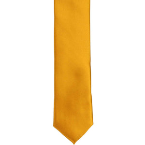 The front of a nugget gold solid skinny tie, laid out flat