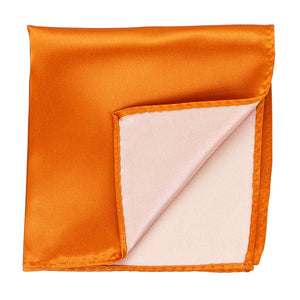 An orange pocket square with the corner flipped up to show the inside