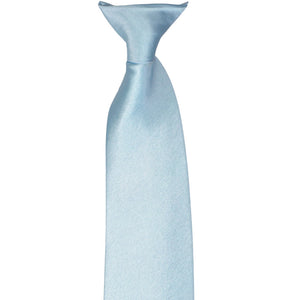 The knot on a pale blue clip-on tie, laid flat