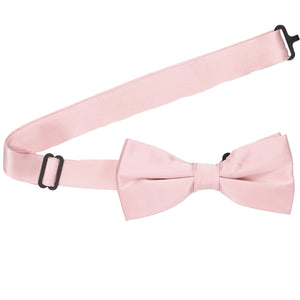 A pastel pink pre-tied bow tie with the band collar open