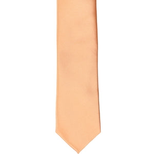 The front of a peach skinny tie, laid flat