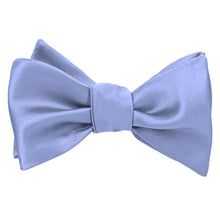 Load image into Gallery viewer, A tied periwinkle blue self-tie bow tie with a satin-like finish, shown against a plain white background.
