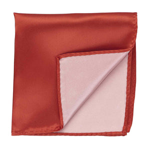 A persimmon pocket square, folded to show the back side