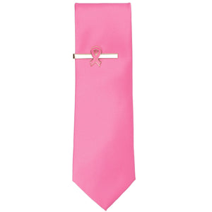 A pink ribbon tie bar on a pink solid color necktie