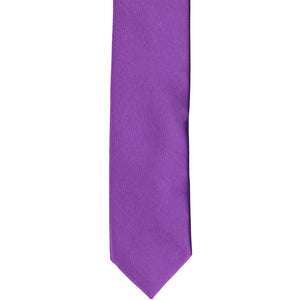 The front of a plum violet skinny tie, laid flat