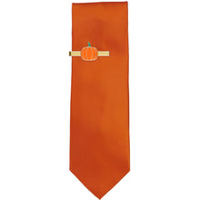Load image into Gallery viewer, Novelty gold tie bar with a pumpkin emblem on a burnt orange tie.