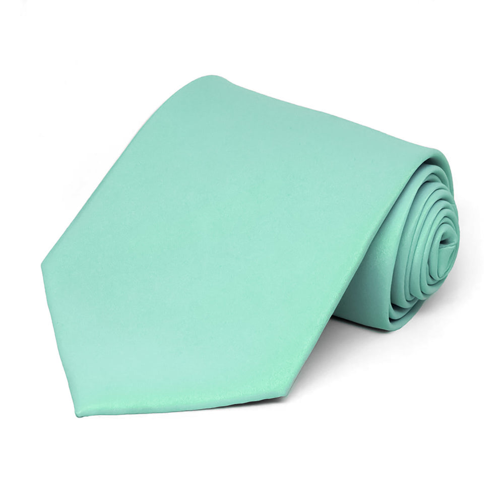 A rolled solid color tie in a light blue-green shade