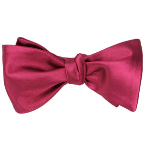 A ruby red self-tie bow tie, tied