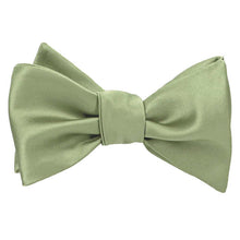 Load image into Gallery viewer, A tied self-tie bow tie in a light sage green color, shown against a plain white background.