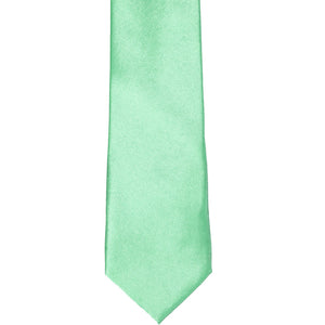 The front of a seafoam solid tie, laid out flat