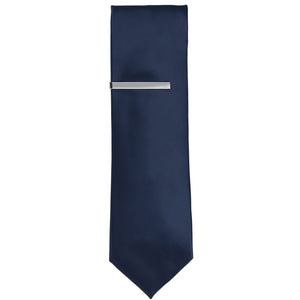 A silver tie bar on a navy blue tie