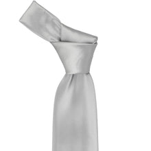 Load image into Gallery viewer, Close-up of a solid silver necktie knot, highlighting the tone and subtle ribbed texture of the fabric.