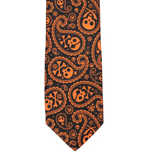 The front of an orange and black skull and crossbones paisley tie, laid out flat