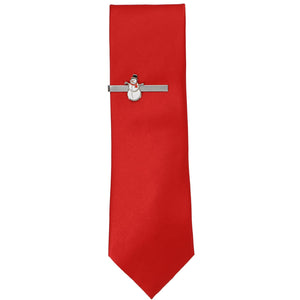 A silver snowman tie bar on a solid red necktie