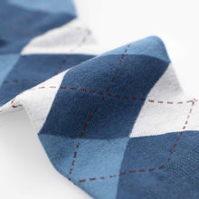 Load image into Gallery viewer, Close-up of dusty blue and light gray argyle sock fabric with brown stitching on a white background