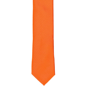 The front of a tangerine skinny solid tie, laid flat