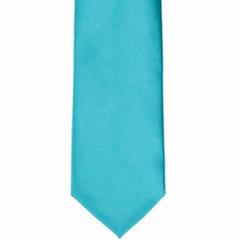 Load image into Gallery viewer, The bottom of a turquoise solid color tie, laid out flat