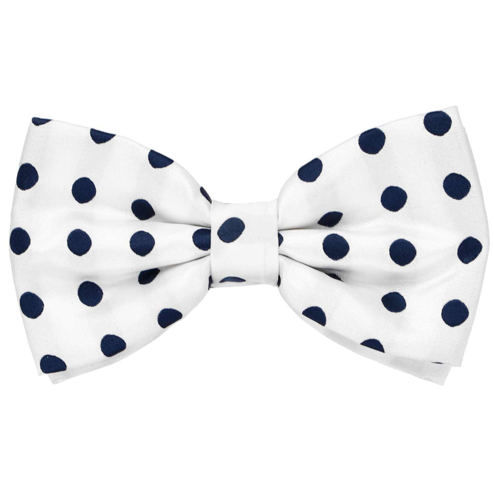 A white pre-tied bow tie with navy blue polka dots