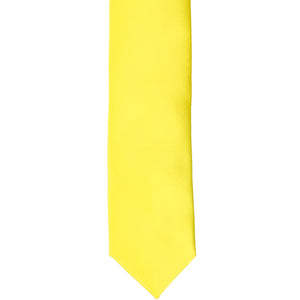 The front of a yellow skinny tie, laid out flat